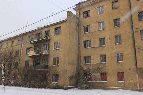 snowfall on the background of an abandoned building
