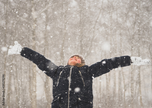 Little girl with arms wide open in snow weather.