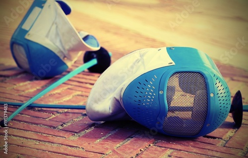equipment fencing mask and foil resting on the ground after the defeat with vintage effect photo