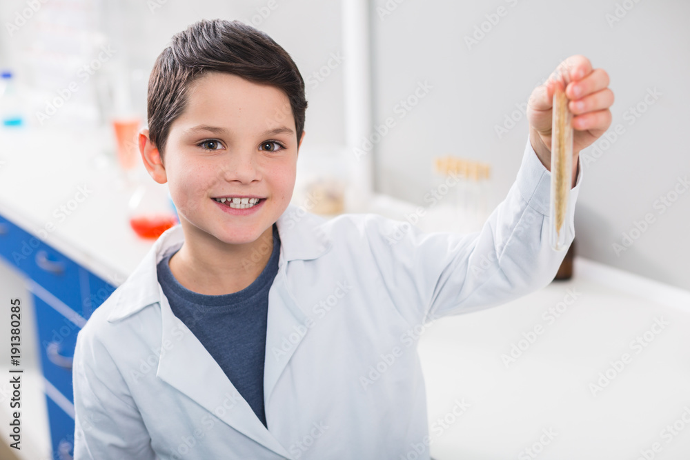 Cheerful jolly boy achieving progress in experiment Cheerful jolly boy achieving progress in experiment