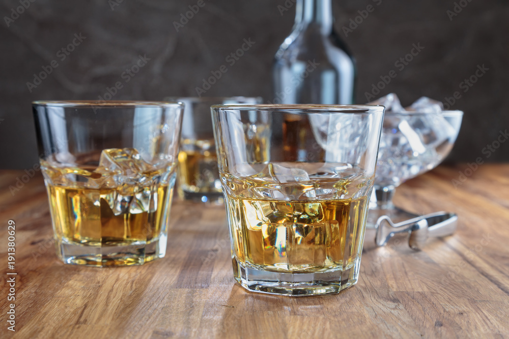 three glasses of whiskey on the oak surface of the table