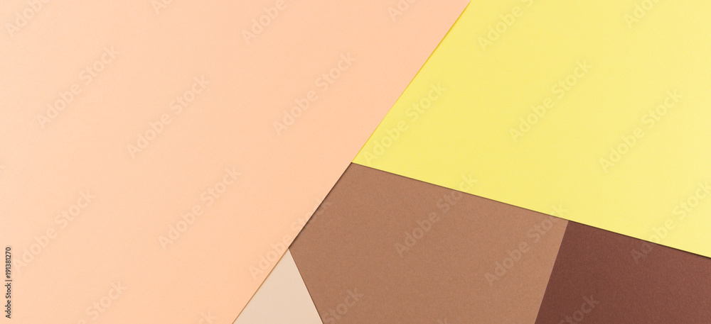 Color papers geometry composition background with yellow pink, beige and brown tones.