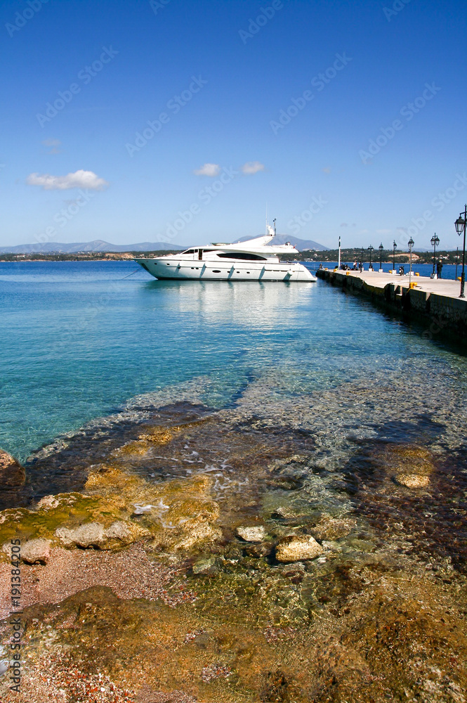 Fototapeta premium Luxury motor boat and the pier in the port of Spetses island, Greece