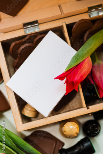 Bouquet of red tulips, chocolate hearts and chess photo