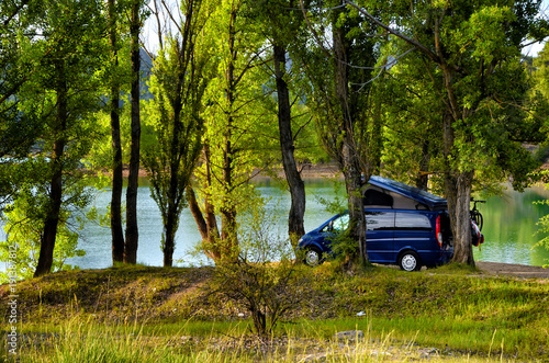 Camper van parked under trees