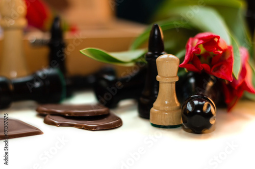 Bouquet of red tulips, chocolate hearts and chess photo