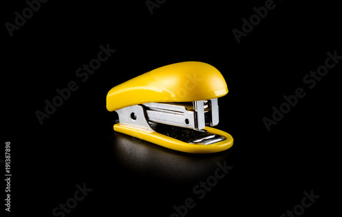 Yellow stapler close-up on a black background photo