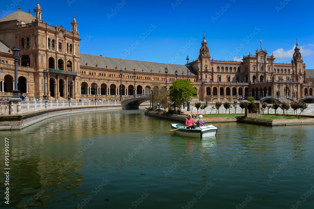 Senior couple sailing boat in canal Plaza de Espana, Sevilla, Andalucia