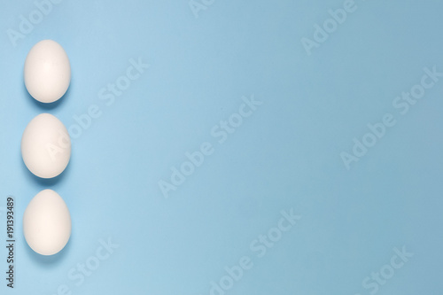 Top view of white eggs isolated on pale blue background.
