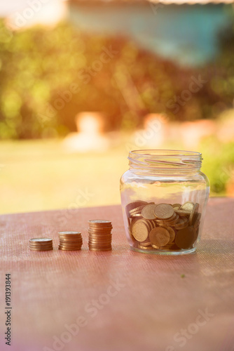 A transparent jar with many coins saved photo