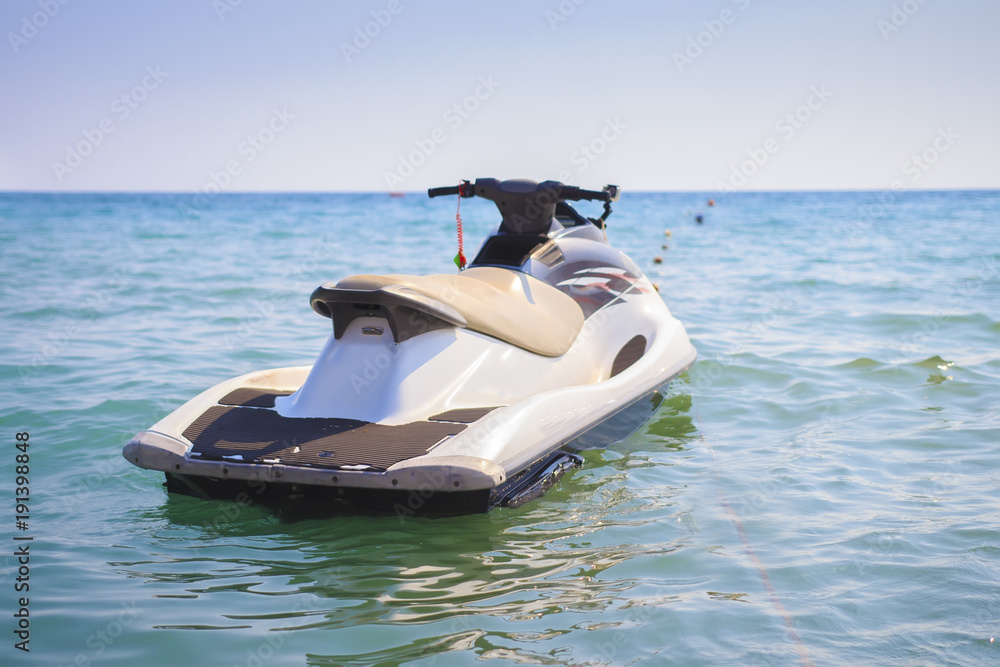 Naklejka premium Water motorcycle in the blue sea on clear sunny day. Water bike on waves of sea.