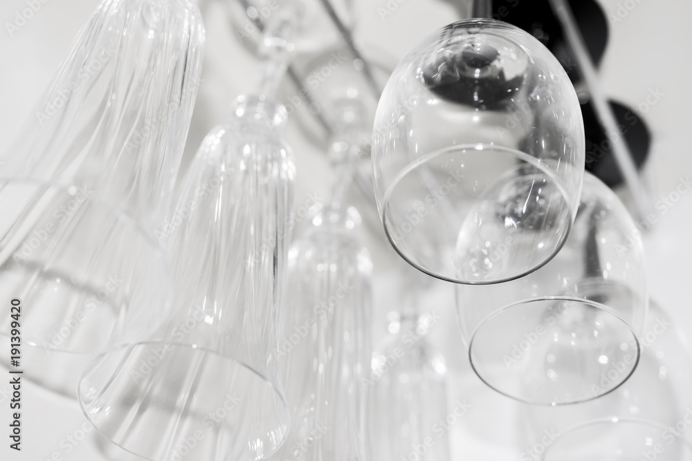 Glass glasses for wine and champagne hang in a bar in a row. Glass glasses for wine and champagne hang in a bar in a row.
