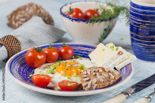 Coffee cup, one egg, cheese and cherry tomatoes for healthy breakfast.