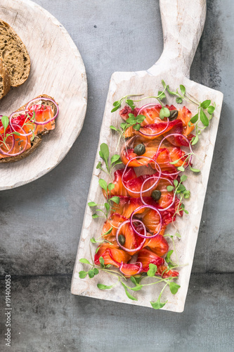 Gravlax - cured salmon or trout with onion and bread photo