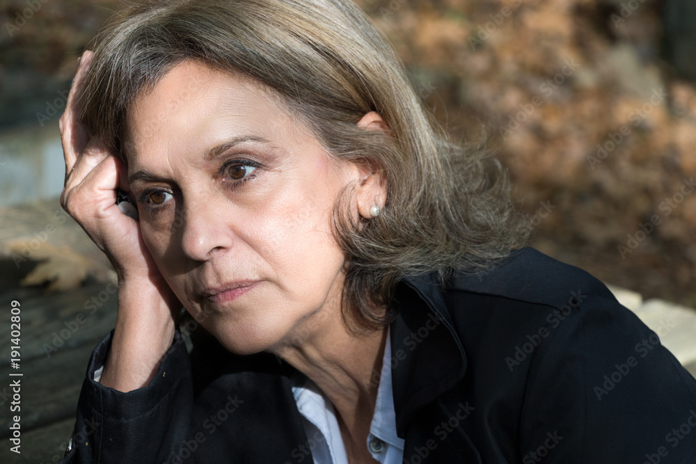 Portrait of a senior woman sad, hand on face, outdoors. Portrait of a senior woman sad, hand on face, outdoors.