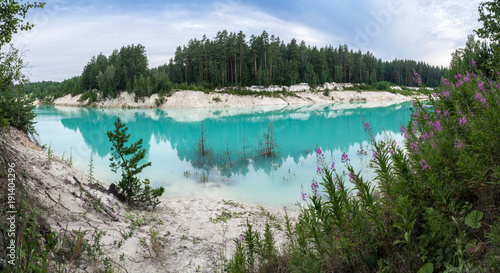Abandoned flooded clay quarry in the middle of forest