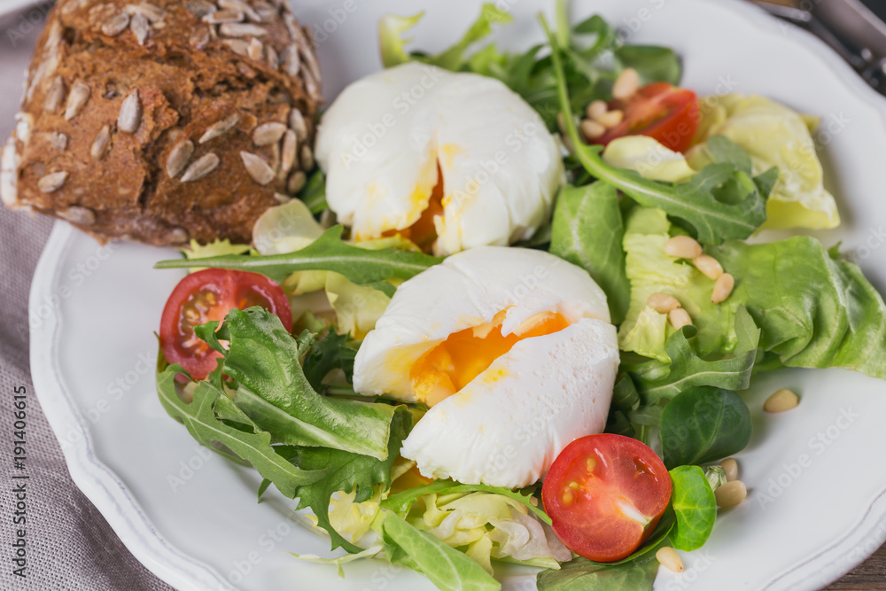 Poached egg with green salad, tomatoes and wholemeal bread Poached egg with green salad, tomatoes and wholemeal bread