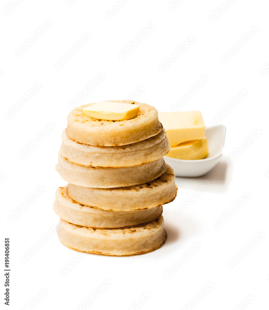 Hot toasted crumpets with butter slice isolated on white Hot toasted crumpets with butter slice isolated on white