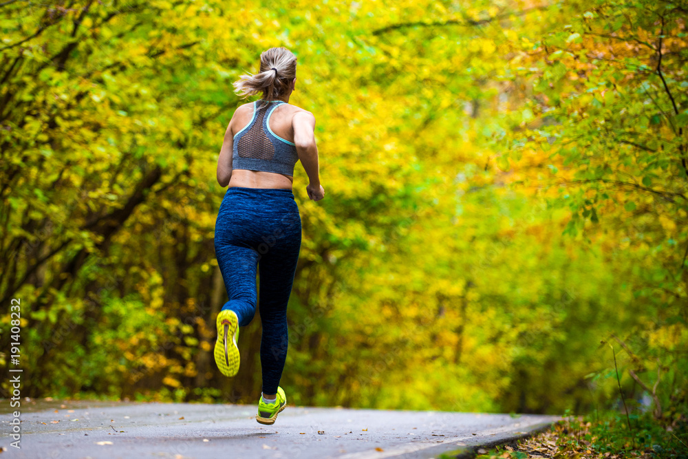Fototapeta premium Woman running in the autumn park