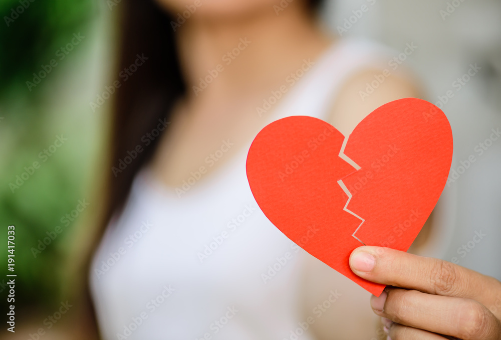 Young woman showing red ripped paper heart. Broken hearted on Valentines day concept. Young woman showing red ripped paper heart. Broken hearted on Valentines day concept.