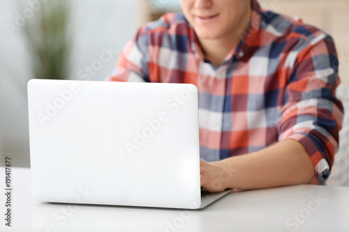 Man using laptop at table i...