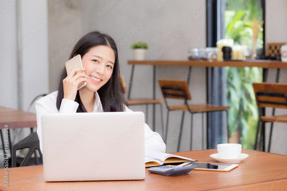 Beautiful asian young businesswoman excited and glad of success with laptop, girl taking mobile phone and working coffee shop on cement background, career freelance business concept. Beautiful asian young businesswoman excited and glad of success with laptop, girl taking mobile phone and working coffee shop on cement background, career freelance business concept.