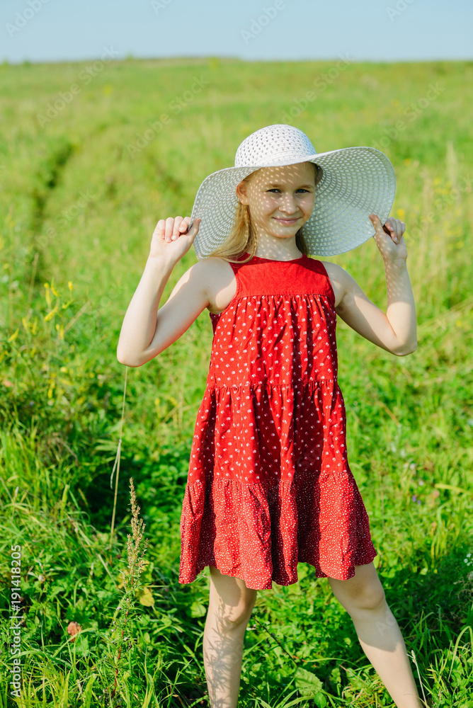 Little girl in red dress and white hat 