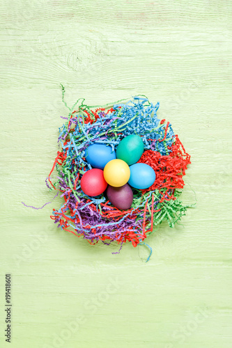 Image of multi-colored Easter eggs on green wooden background