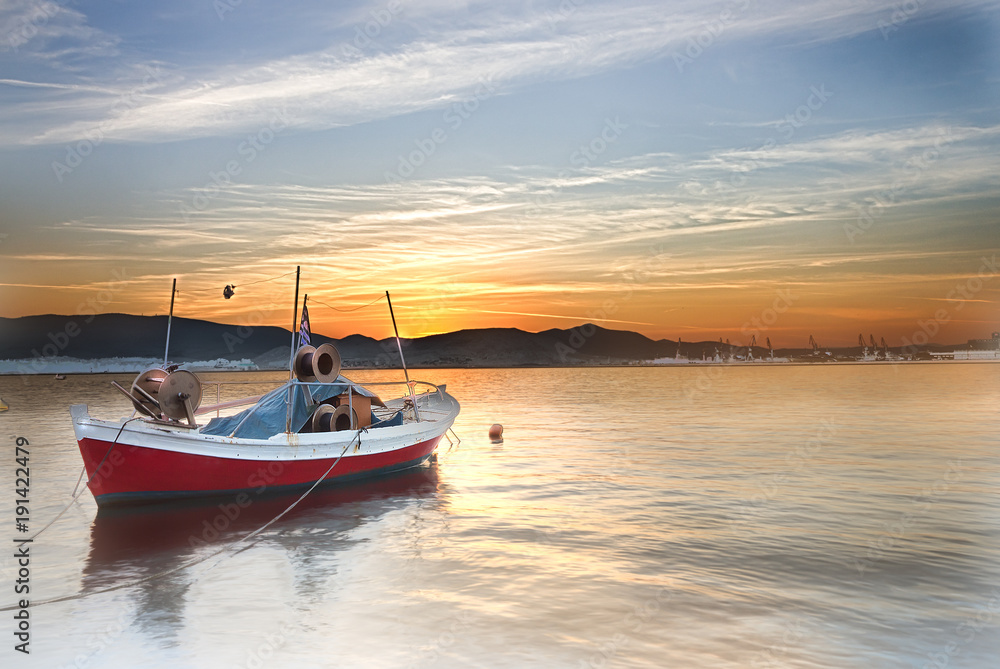 Small boat on a sea at sunset.