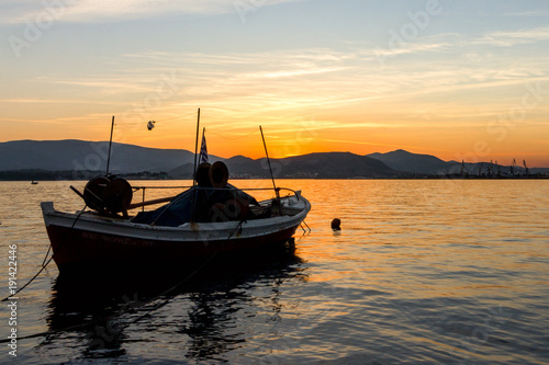 Small boat on a sea at sunset. © Ruben