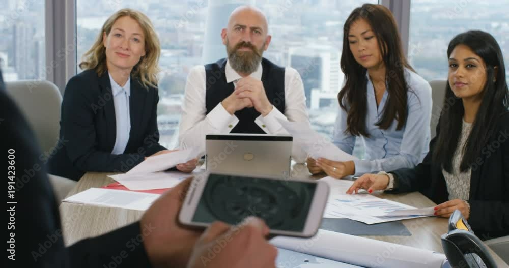 4K Businessman using smartphone to communicate ideas to colleagues in business presentation. Slow motion.