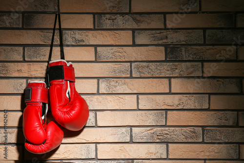 Boxing gloves on brick wall © Africa Studio