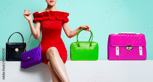 Wallpaper Mural Woman with red dress sitting with many colourful purses. Torontodigital.ca