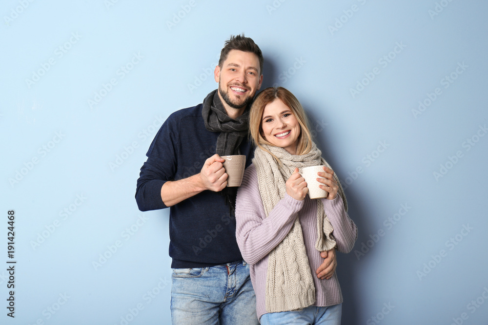 Young couple in warm clothing on color background. Ready for winter vacation Young couple in warm clothing on color background. Ready for winter vacation