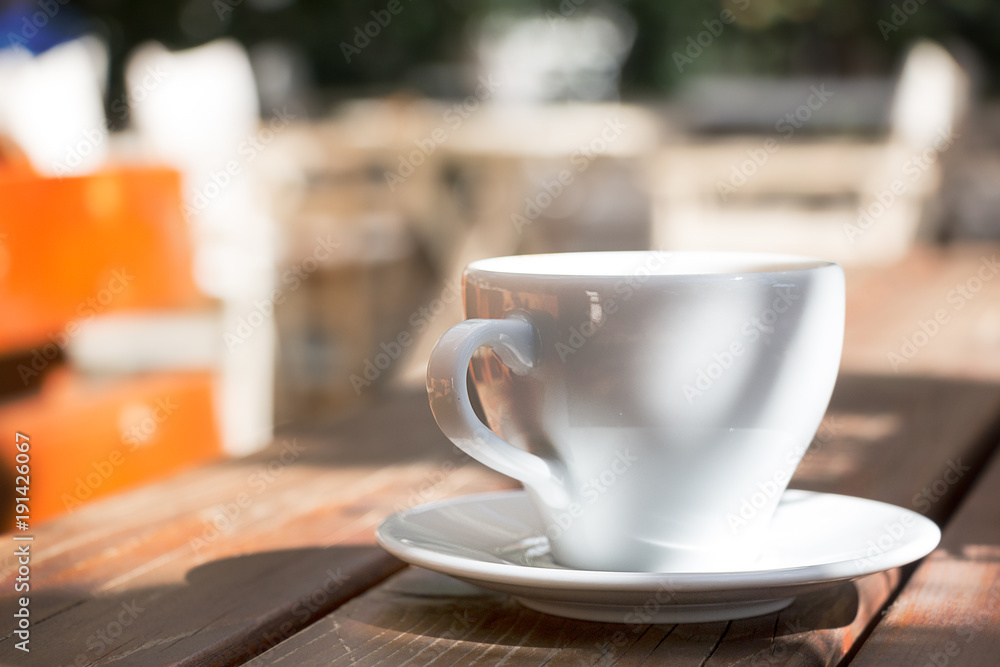 A coffee mug with plate outdoors.