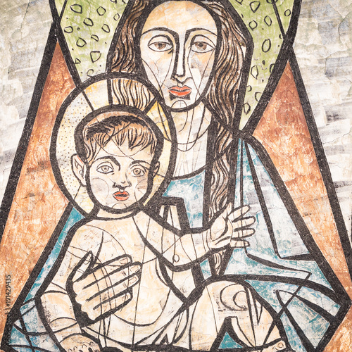 Virgin Mary with baby Jesus painted on a wall of the ancient cemetery of San Candido.