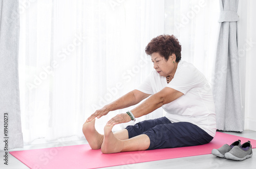 Asian senior woman doing exercise at home.