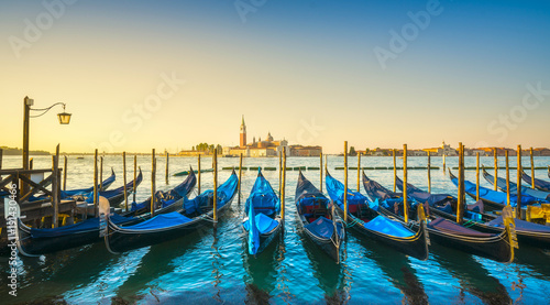 Venice lagoon, San Giorgio church, gondolas and poles. Italy © stevanzz