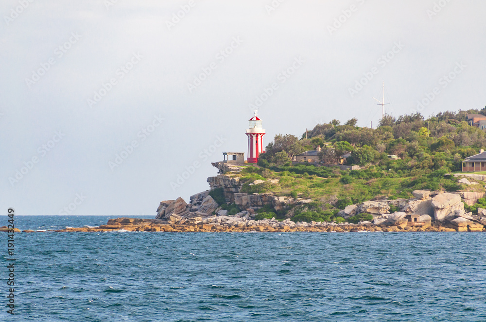 Bright red and white lighthouse on a cliff