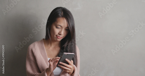 Woman using smart phone over gray background