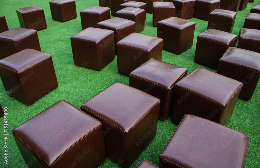 Fototapeta premium Brown Cube chair On the grass background