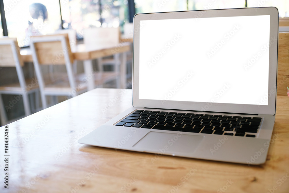 Laptop with Mock up blank screen on wooden table in front of coffeeshop cafe space for text. product display montage- technology concept Laptop with Mock up blank screen on wooden table in front of coffeeshop cafe space for text. product display montage- technology concept