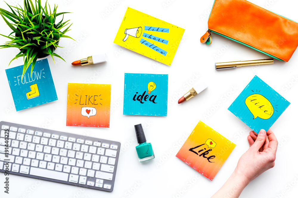 Work desk of beauty blogger with social media icons and cosmetics on white background top view Work desk of beauty blogger with social media icons and cosmetics on white background top view