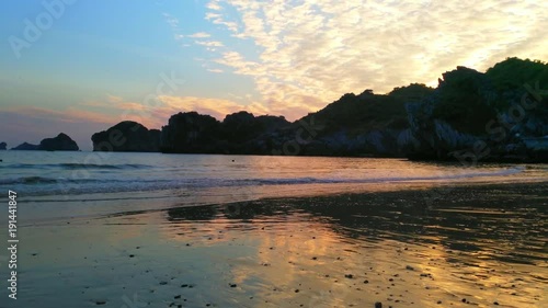 Mom and kid playing on a beach UHD Handheld pan view of a beach outside Cat ba city, in the halong bay on a sunny december evening dusk sunset photo