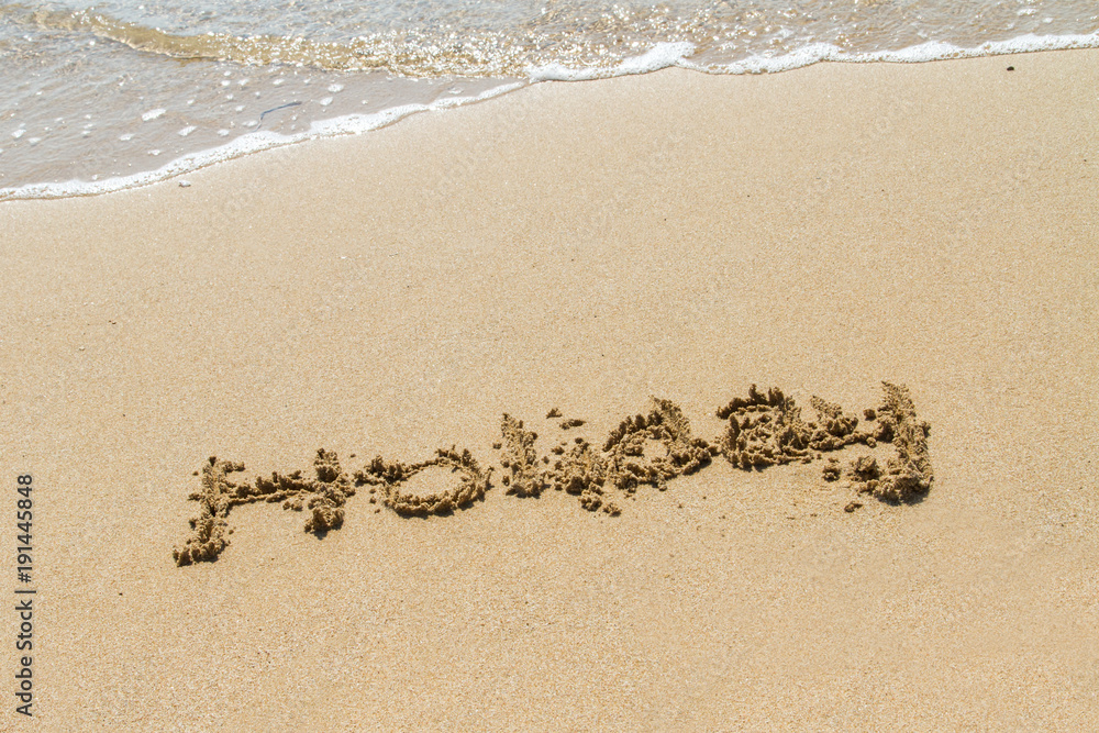 Obraz premium Word of Holiday on Sand