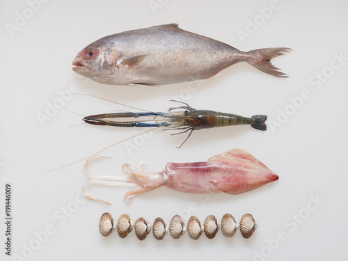 Mix seafood, black-banded trevally fish, tiger prawn, cuttlefish, and cockle, isolated on white background photo