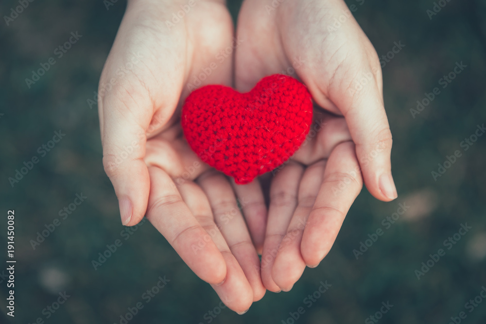 Sharing Love and Heart red color on women hand in valentine's day vintage color tone Sharing Love and Heart red color on women hand in valentine's day vintage color tone