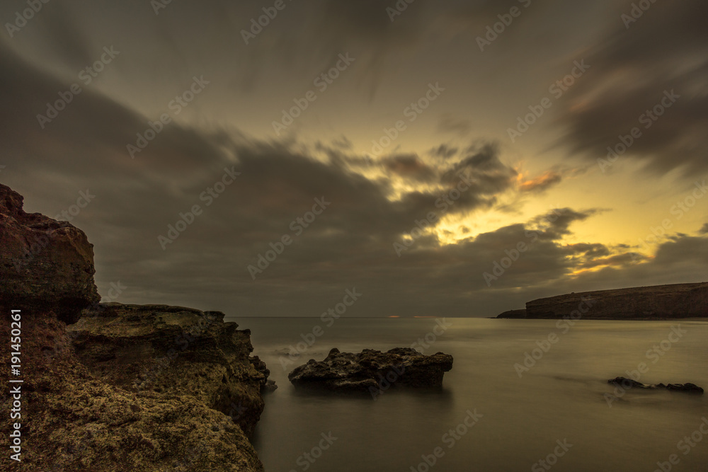 Obraz premium Beach with big lava stones at sunset. Canary Islands and long exposure