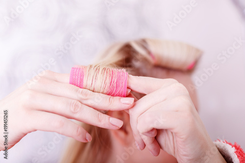 Tableau sur toile Pretty young woman wind the hair in curlers