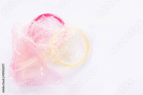 Condoms used yellow and pink  give Filing condom safe sex concept on the bed Prevent infection hiv.
